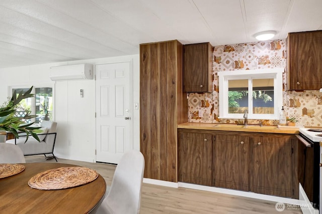 6219 Shamrock Rd, Maple Falls, WA 98266 - kitchen with a wall mounted air conditioner, wallpapered walls, light countertops, light wood-type flooring, and range with electric cooktop