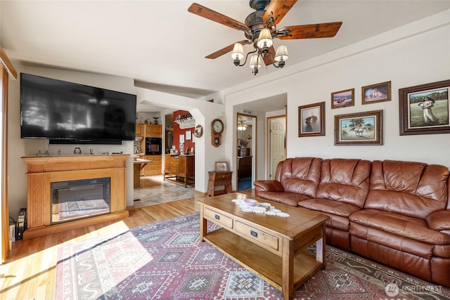 836 Harman Way S Unit 82, Orting, WA 98360 - living area featuring a ceiling fan, light wood-style flooring, and a glass covered fireplace