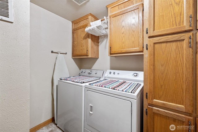836 Harman Way S Unit 82, Orting, WA 98360 - washroom featuring washer and dryer, cabinet space, and a textured wall