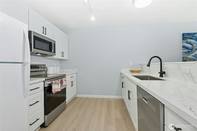 17426 Bothell Way NE Unit A105, Bothell, WA 98011 - kitchen with stainless steel appliances, light wood-type flooring, white cabinets, light stone counters, and rail lighting
