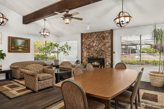 17431 Ambaum Blvd S Unit C24, Burien, WA 98148 - dining space featuring a chandelier, ceiling fan, dark wood-type flooring, and a stone fireplace