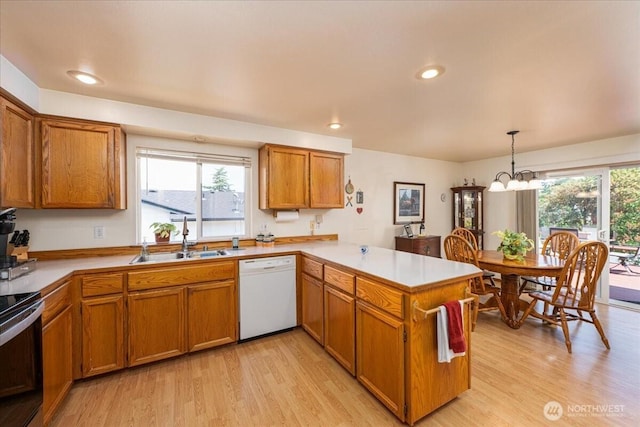 1890 Edgewood Dr, Camano Island, WA 98282 - kitchen with white dishwasher, a peninsula, brown cabinetry, light wood-style flooring, and recessed lighting