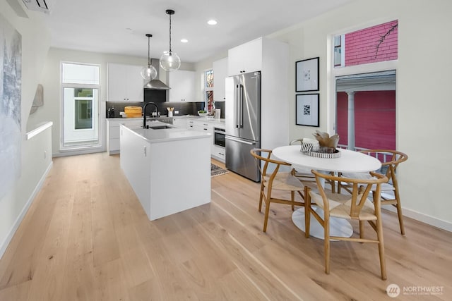 501 11th Ave E, Seattle, WA 98102 - kitchen with appliances with stainless steel finishes, light countertops, light wood-style floors, white cabinetry, and recessed lighting
