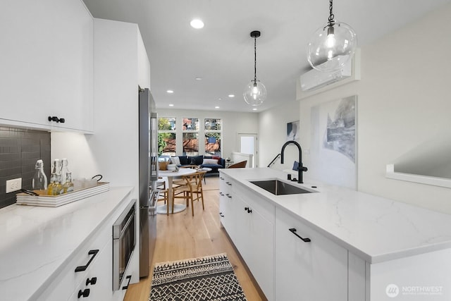 501 11th Ave E, Seattle, WA 98102 - kitchen with light wood finished floors, stainless steel appliances, recessed lighting, hanging light fixtures, and open floor plan