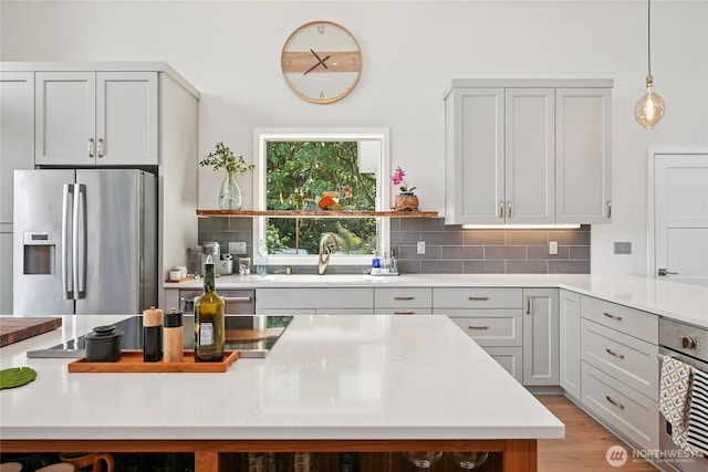 30005 NE 12th Ct, Ridgefield, WA 98642 - kitchen with stainless steel appliances, tasteful backsplash, hanging light fixtures, and open shelves
