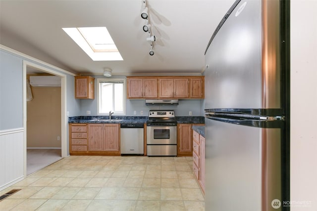 2610 E Section St Unit 85, Mount Vernon, WA 98274 - kitchen featuring stainless steel appliances, under cabinet range hood, a wall unit AC, dark countertops, and brown cabinetry