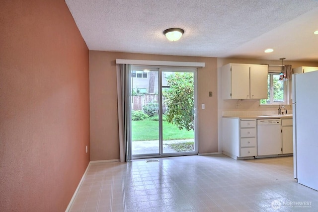5211 53rd St W, University Place, WA 98467 - kitchen with white appliances, healthy amount of natural light, light countertops, a textured ceiling, and white cabinetry