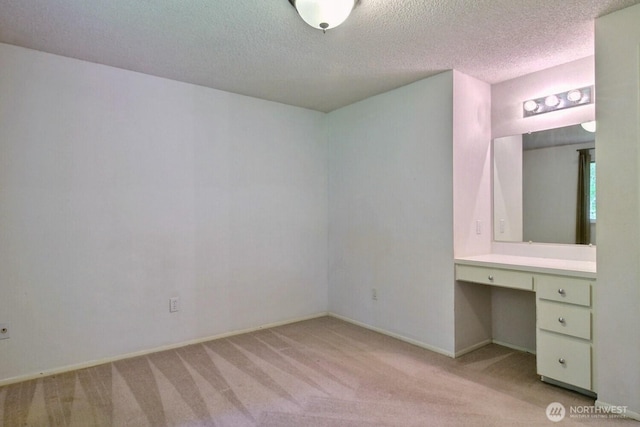 5211 53rd St W, University Place, WA 98467 - unfurnished bedroom featuring built in desk, light colored carpet, and a textured ceiling