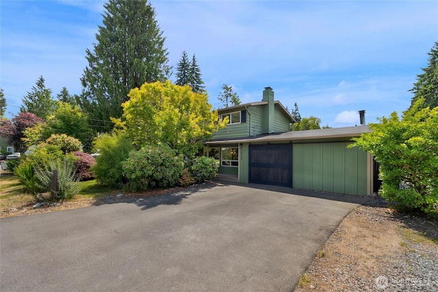 7818 185th Pl SW, Edmonds, WA 98026 - view of front of house featuring a chimney, driveway, and board and batten siding
