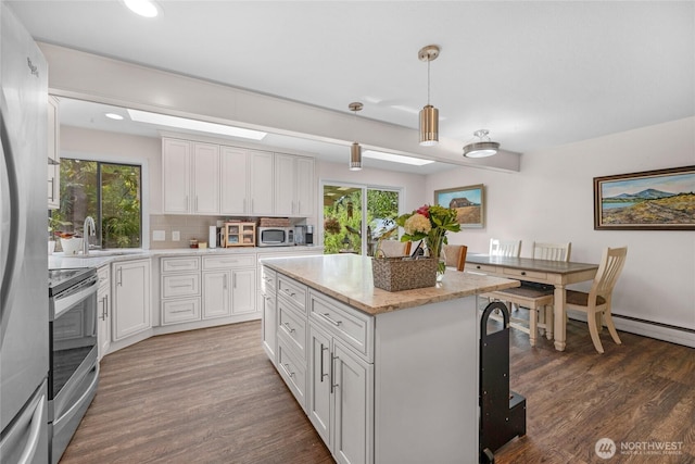 7818 185th Pl SW, Edmonds, WA 98026 - kitchen with appliances with stainless steel finishes, wood finished floors, a center island, white cabinetry, and recessed lighting