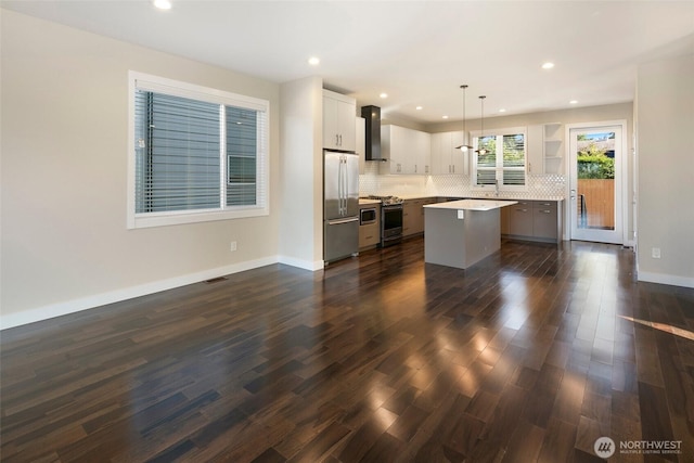 11838 79th Ave S, Seattle, WA 98178 - kitchen with appliances with stainless steel finishes, a kitchen island, wall chimney range hood, decorative backsplash, and dark wood-style flooring