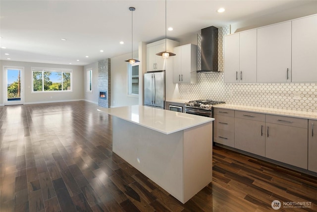 11838 79th Ave S, Seattle, WA 98178 - kitchen with wall chimney range hood, stainless steel appliances, dark wood finished floors, open floor plan, and recessed lighting