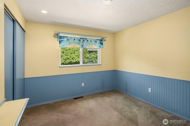 10704 NE 200th Pl, Bothell, WA 98011 - unfurnished room with wainscoting, carpet, and a textured ceiling