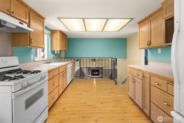 10704 NE 200th Pl, Bothell, WA 98011 - kitchen featuring white appliances, under cabinet range hood, light wood-type flooring, light countertops, and a brick fireplace