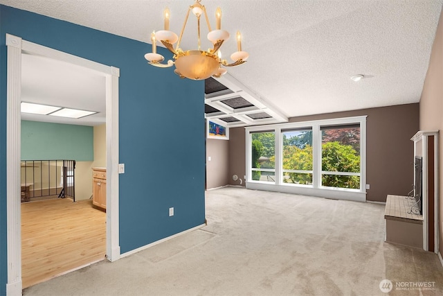 10704 NE 200th Pl, Bothell, WA 98011 - unfurnished living room featuring a chandelier, a textured ceiling, carpet, and coffered ceiling