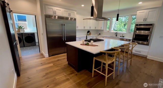 15 Sudden Valley Dr, Bellingham, WA 98229 - kitchen with appliances with stainless steel finishes, island range hood, separate washer and dryer, light wood-type flooring, and recessed lighting