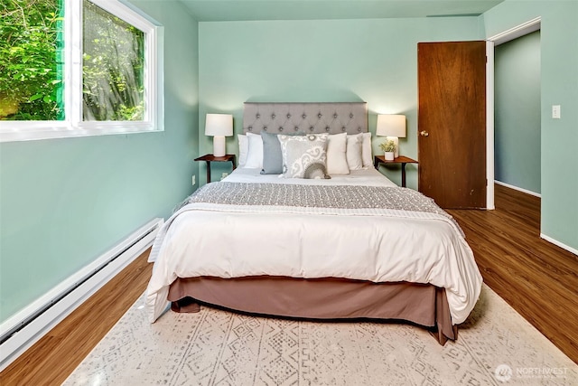 303 N 44th St Unit 105, Seattle, WA 98103 - bedroom featuring a baseboard heating unit and wood finished floors