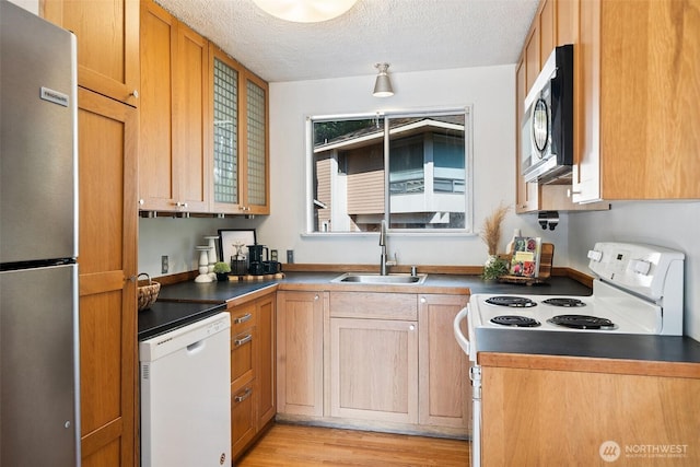 4445 SE Firmont Dr, Port Orchard, WA 98367 - kitchen featuring stainless steel appliances, dark countertops, a textured ceiling, and light wood finished floors