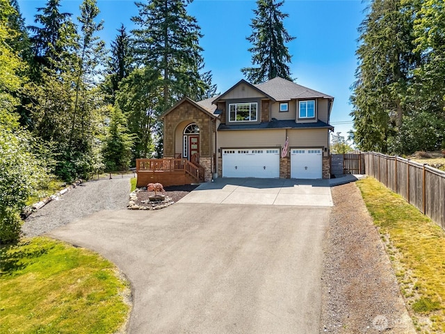 5728 SE 159th Ave, Snohomish, WA 98290 - view of front of property featuring driveway, stone siding, an attached garage, and a wooden deck