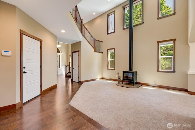 5728 SE 159th Ave, Snohomish, WA 98290 - unfurnished living room with stairway, healthy amount of natural light, a wood stove, recessed lighting, and dark wood finished floors