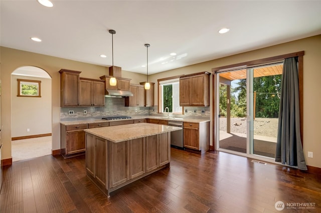5728 SE 159th Ave, Snohomish, WA 98290 - kitchen with stainless steel appliances, tasteful backsplash, under cabinet range hood, arched walkways, and a kitchen island