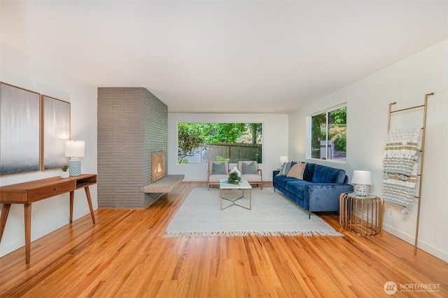 2329 NE 103rd St, Seattle, WA 98125 - living room with healthy amount of natural light, wood finished floors, and a brick fireplace