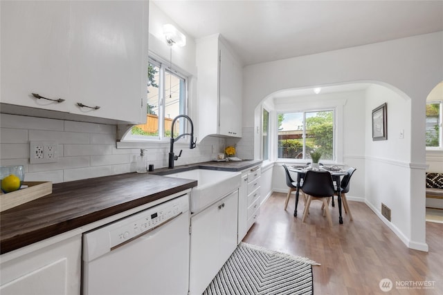 1211 S 41st St, Tacoma, WA 98418 - kitchen with white dishwasher, butcher block counters, arched walkways, light wood-type flooring, and plenty of natural light