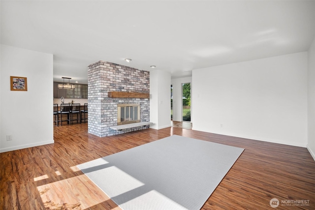 6084 Summit View Pl, Ferndale, WA 98248 - unfurnished living room featuring wood finished floors, a chandelier, and a fireplace