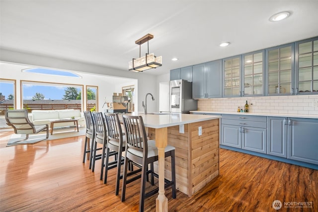 6084 Summit View Pl, Ferndale, WA 98248 - kitchen with smart refrigerator, wood finished floors, a kitchen breakfast bar, an island with sink, and tasteful backsplash
