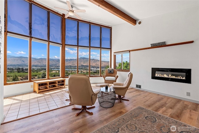 71 Blue Grade Rd, East Wenatchee, WA 98802 - living room with a mountain view, a high ceiling, a glass covered fireplace, plenty of natural light, and beamed ceiling