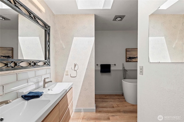71 Blue Grade Rd, East Wenatchee, WA 98802 - bathroom featuring a skylight, wood finished floors, double vanity, and a soaking tub