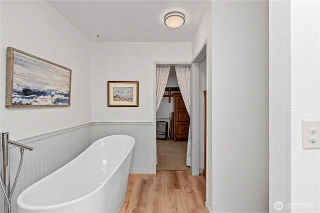 71 Blue Grade Rd, East Wenatchee, WA 98802 - bathroom featuring wood finished floors, a soaking tub, and wainscoting