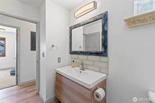 71 Blue Grade Rd, East Wenatchee, WA 98802 - bathroom featuring vanity, wood finished floors, electric panel, and backsplash