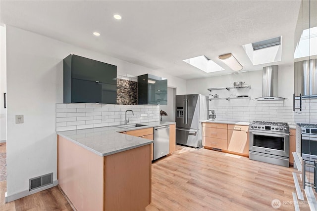 71 Blue Grade Rd, East Wenatchee, WA 98802 - kitchen featuring stainless steel appliances, wall chimney range hood, open shelves, a skylight, and backsplash