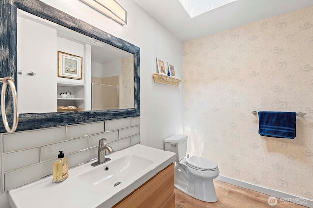 71 Blue Grade Rd, East Wenatchee, WA 98802 - bathroom featuring wood finished floors, wallpapered walls, vanity, a skylight, and a shower