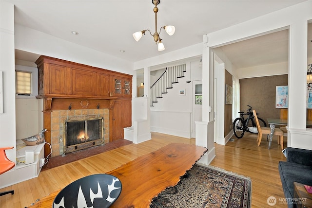 1222 N 4th St, Tacoma, WA 98403 - living room with light wood finished floors, stairs, a fireplace with flush hearth, and a chandelier
