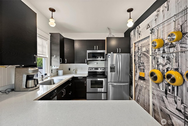 1222 N 4th St, Tacoma, WA 98403 - kitchen featuring appliances with stainless steel finishes, dark cabinets, light countertops, and pendant lighting