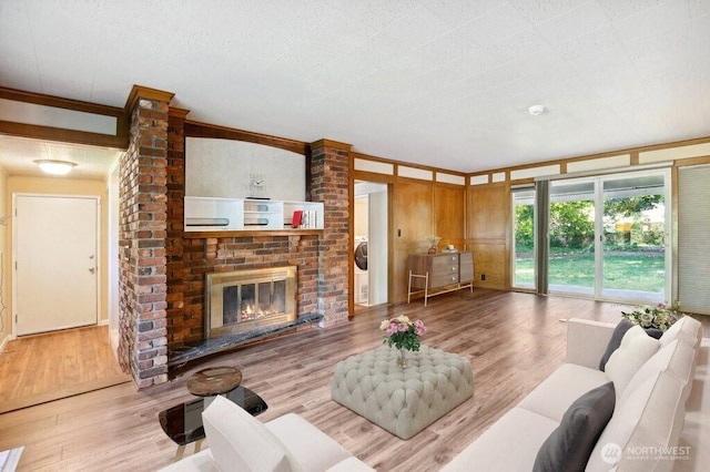1111 Garrison Ave, Port Orchard, WA 98366 - living room featuring wood finished floors, crown molding, and a brick fireplace