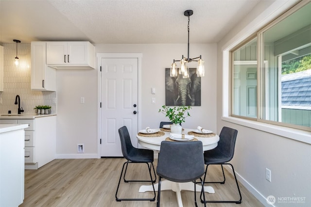 1626 E 59th St, Tacoma, WA 98404 - dining space with a chandelier, light wood-style floors, and a textured ceiling