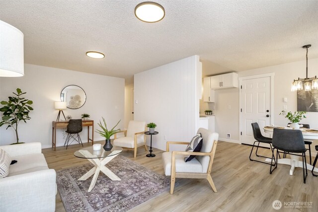 1626 E 59th St, Tacoma, WA 98404 - living area with light wood-style flooring, a textured ceiling, and a chandelier