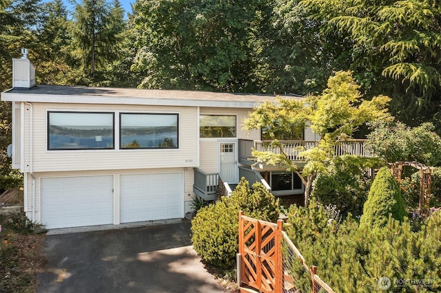 27727 94th Ave SW, Vashon, WA 98070 - view of front facade featuring an attached garage, a chimney, and driveway