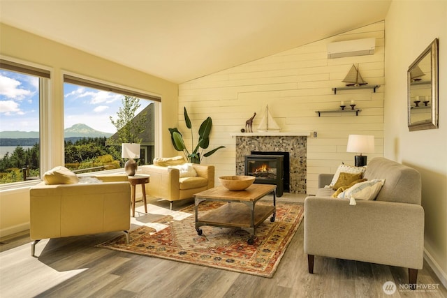 27727 94th Ave SW, Vashon, WA 98070 - living room featuring lofted ceiling, wood finished floors, a fireplace, a mountain view, and a wall unit AC