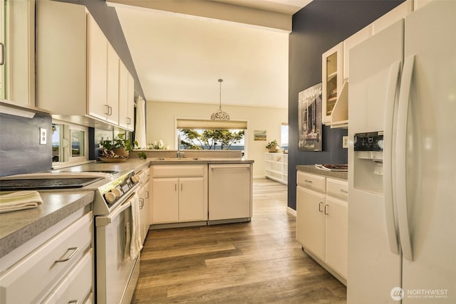 27727 94th Ave SW, Vashon, WA 98070 - kitchen featuring white appliances, wood finished floors, a peninsula, lofted ceiling, and decorative light fixtures