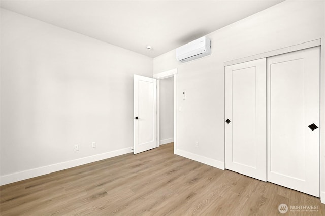 710 E 4th St, Nooksack, WA 98276 - unfurnished bedroom with an AC wall unit, light wood finished floors, and a closet