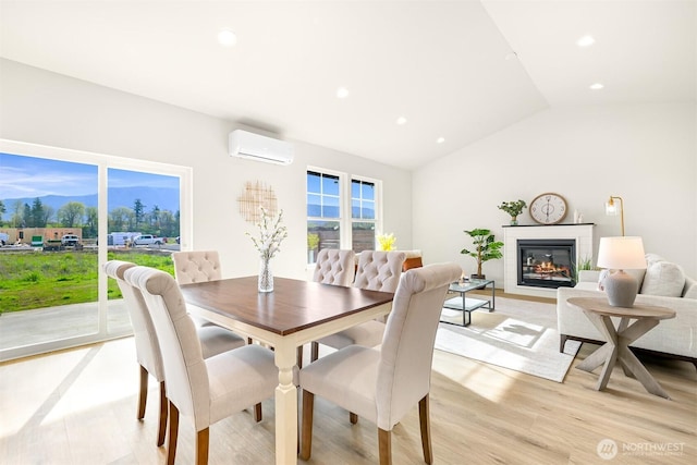 710 E 4th St, Nooksack, WA 98276 - dining space with a wall mounted AC, recessed lighting, light wood finished floors, a glass covered fireplace, and lofted ceiling