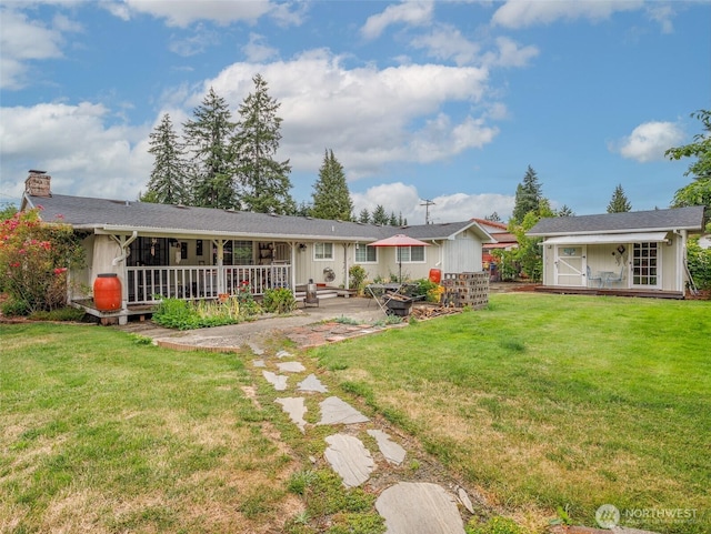 6725 Husky Way SE, Olympia, WA 98503 - rear view of house featuring a yard, a chimney, a patio area, and a storage unit