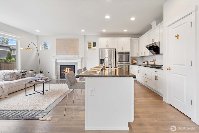 23228 SE 50th St, Issaquah, WA 98029 - kitchen with open floor plan, stainless steel appliances, range hood, recessed lighting, and white cabinets