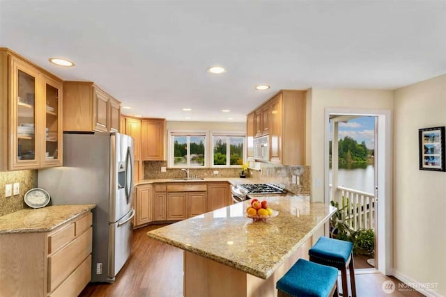 3607 Walthew Dr SE, Lacey, WA 98503 - kitchen featuring a peninsula, stainless steel fridge, range, wood finished floors, and a breakfast bar area
