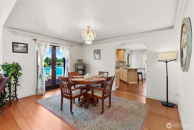 3607 Walthew Dr SE, Lacey, WA 98503 - dining space featuring arched walkways, light wood-style flooring, a chandelier, french doors, and ornamental molding