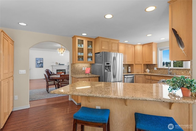 3607 Walthew Dr SE, Lacey, WA 98503 - kitchen with appliances with stainless steel finishes, arched walkways, a peninsula, dark wood-type flooring, and glass insert cabinets